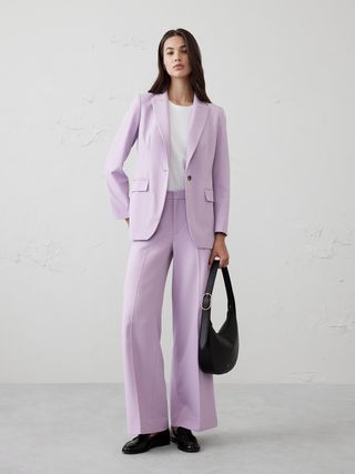 Image may contain Clothing Formal Wear Suit Tuxedo Coat Blazer Jacket Accessories Bag and Handbag