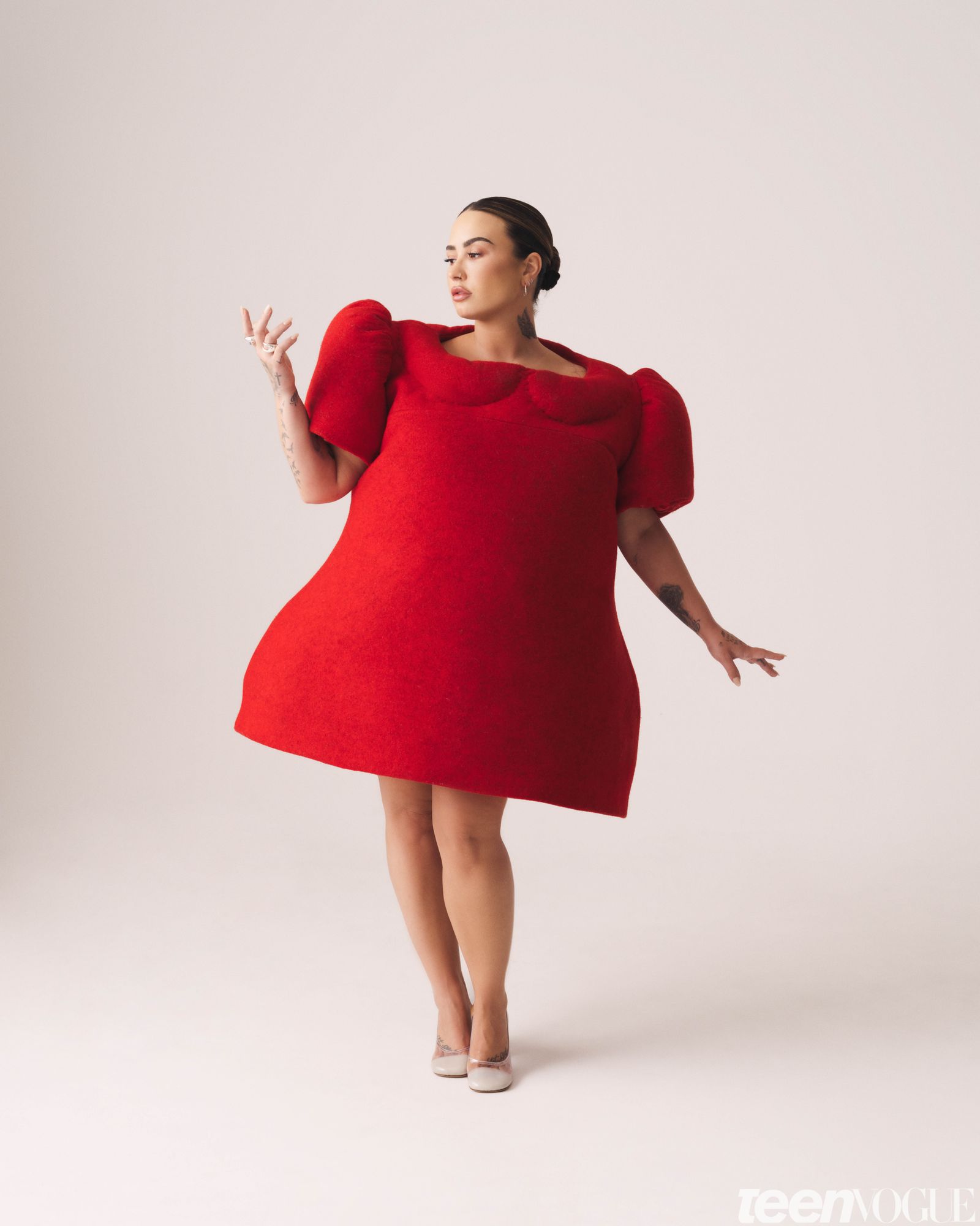 Demi wears a bright red dolllike dress.