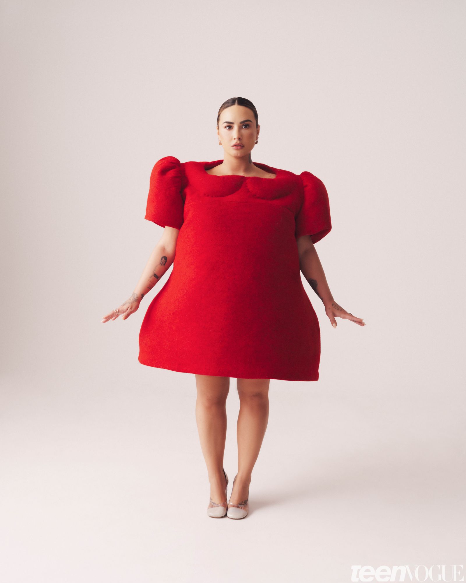 Demi wears a bright red dolllike dress.