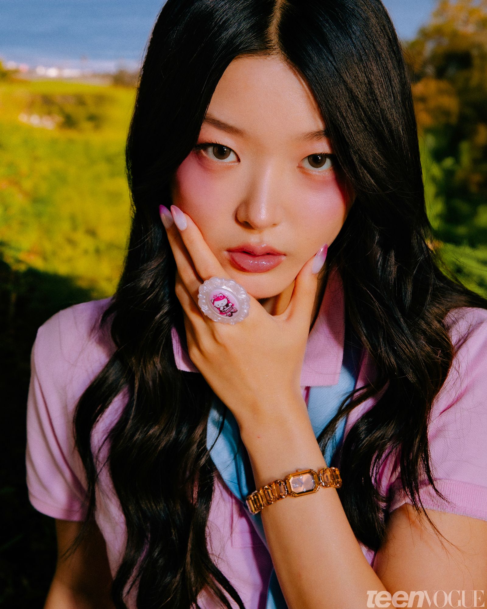 Closeup of Yoonchae of KATSEYE in the backyard with her hand holding her chin.