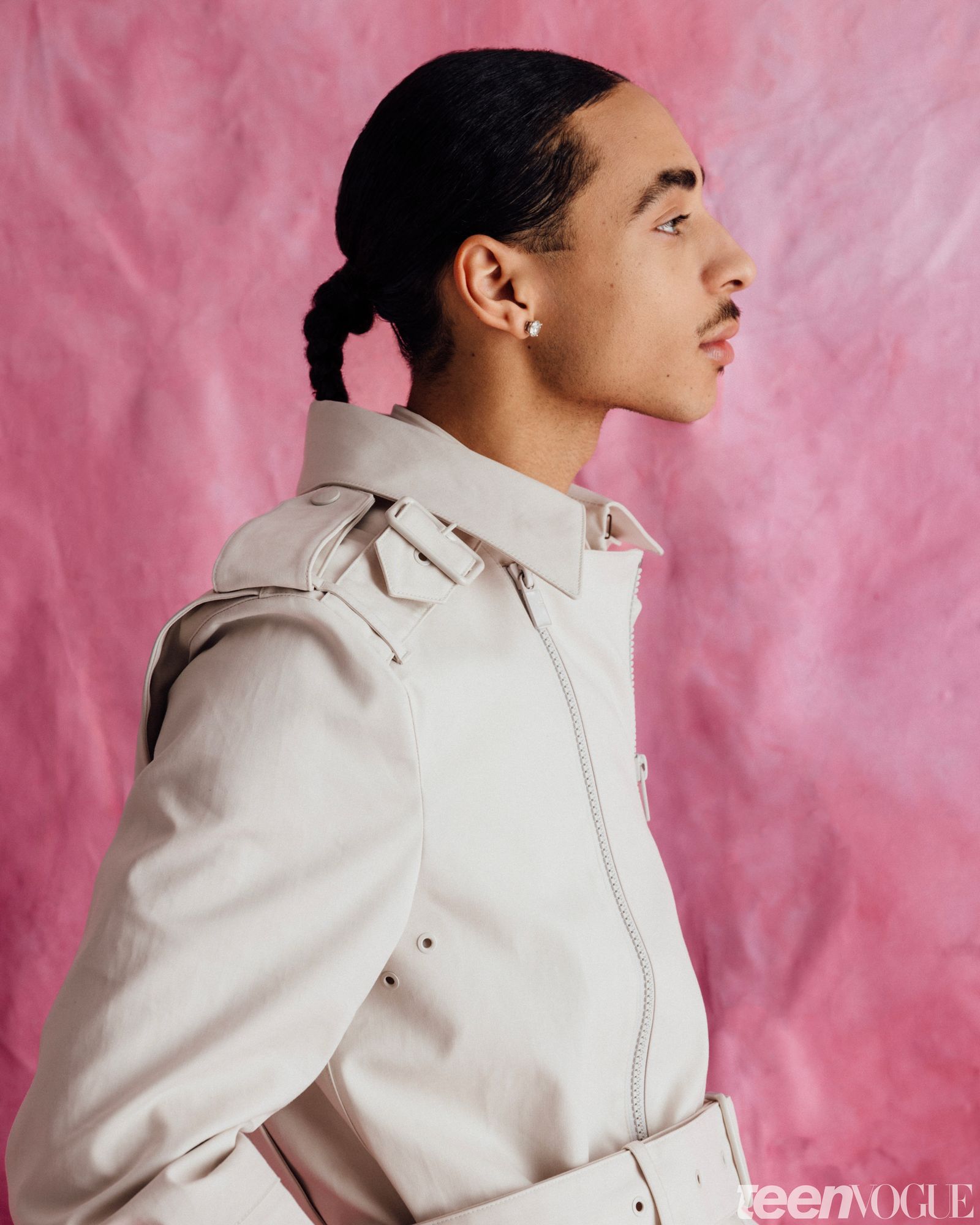 Profile portrait of Julez in a structured eggshell jacket against a pink canvas backdrop.