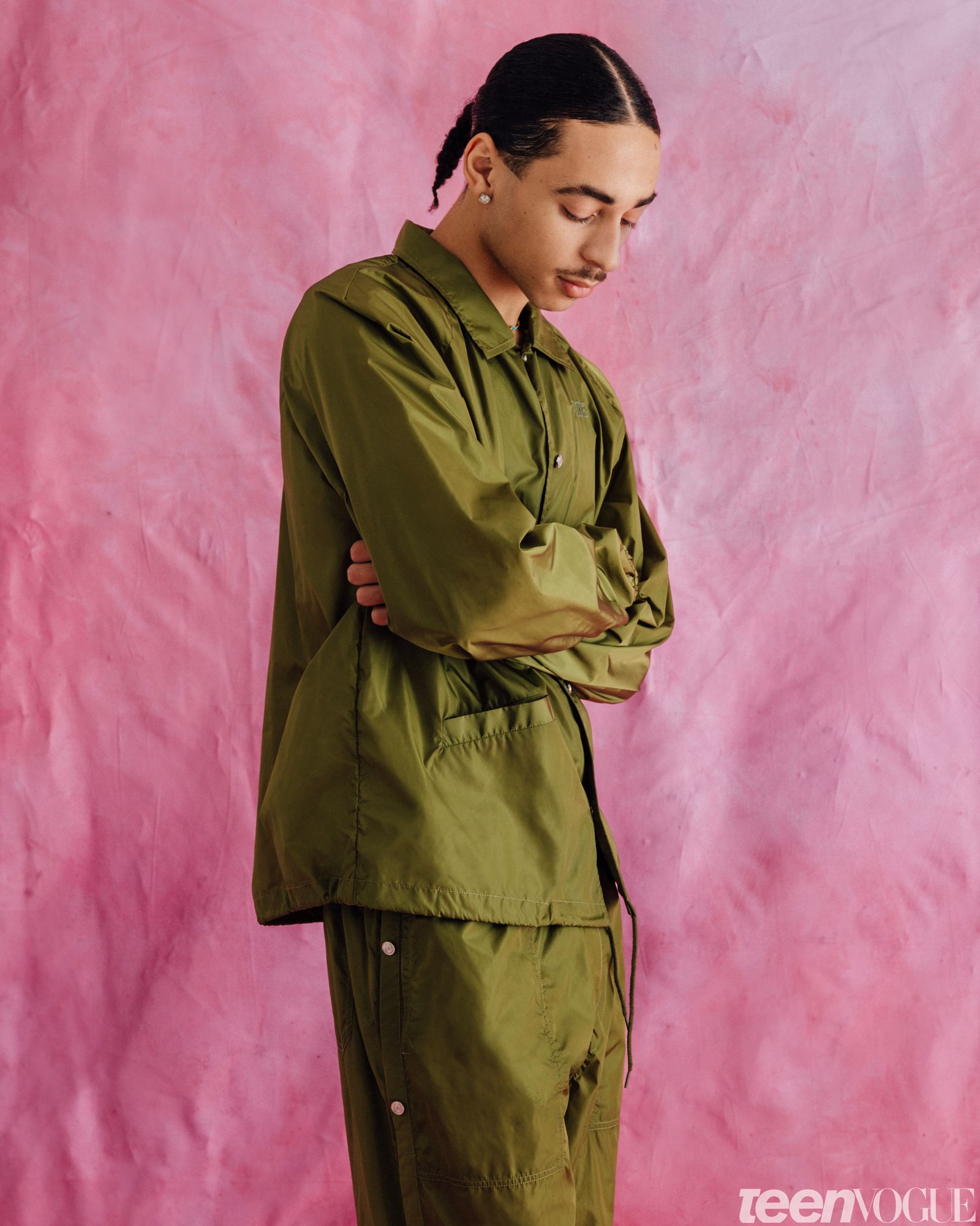 Julez standing with his arms folded looking down.