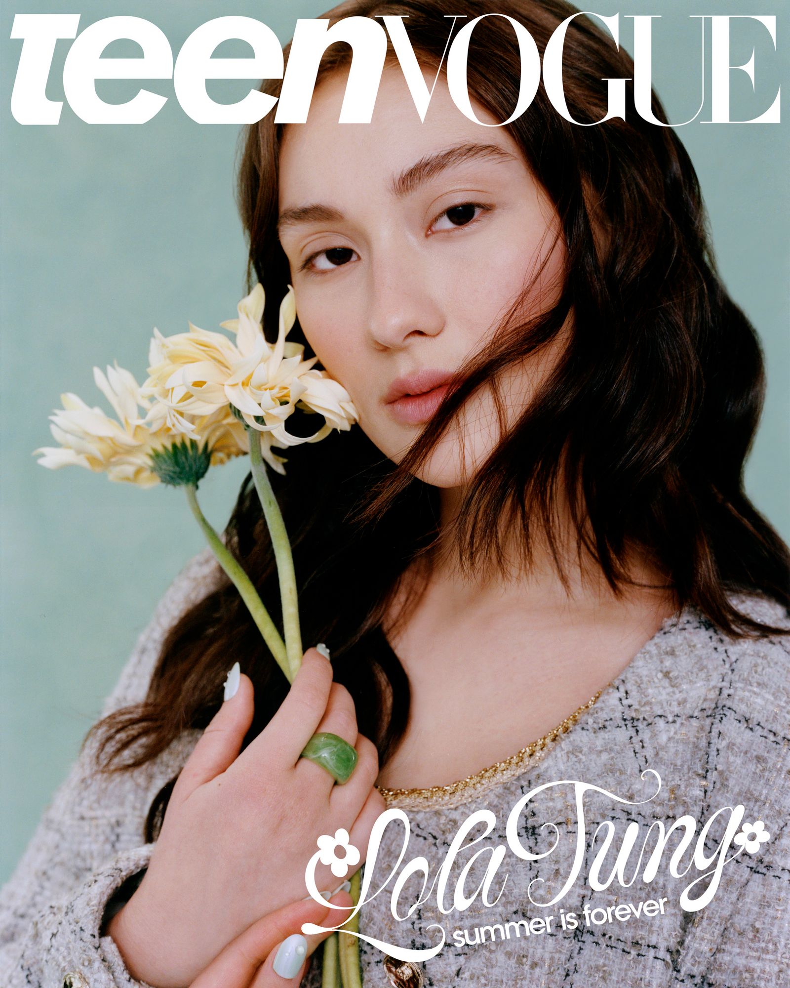 Teen Vogue Lola Tung Cover July 2025. Lola is wearing a tweed jacket and gently holding two yellow flowers by their...