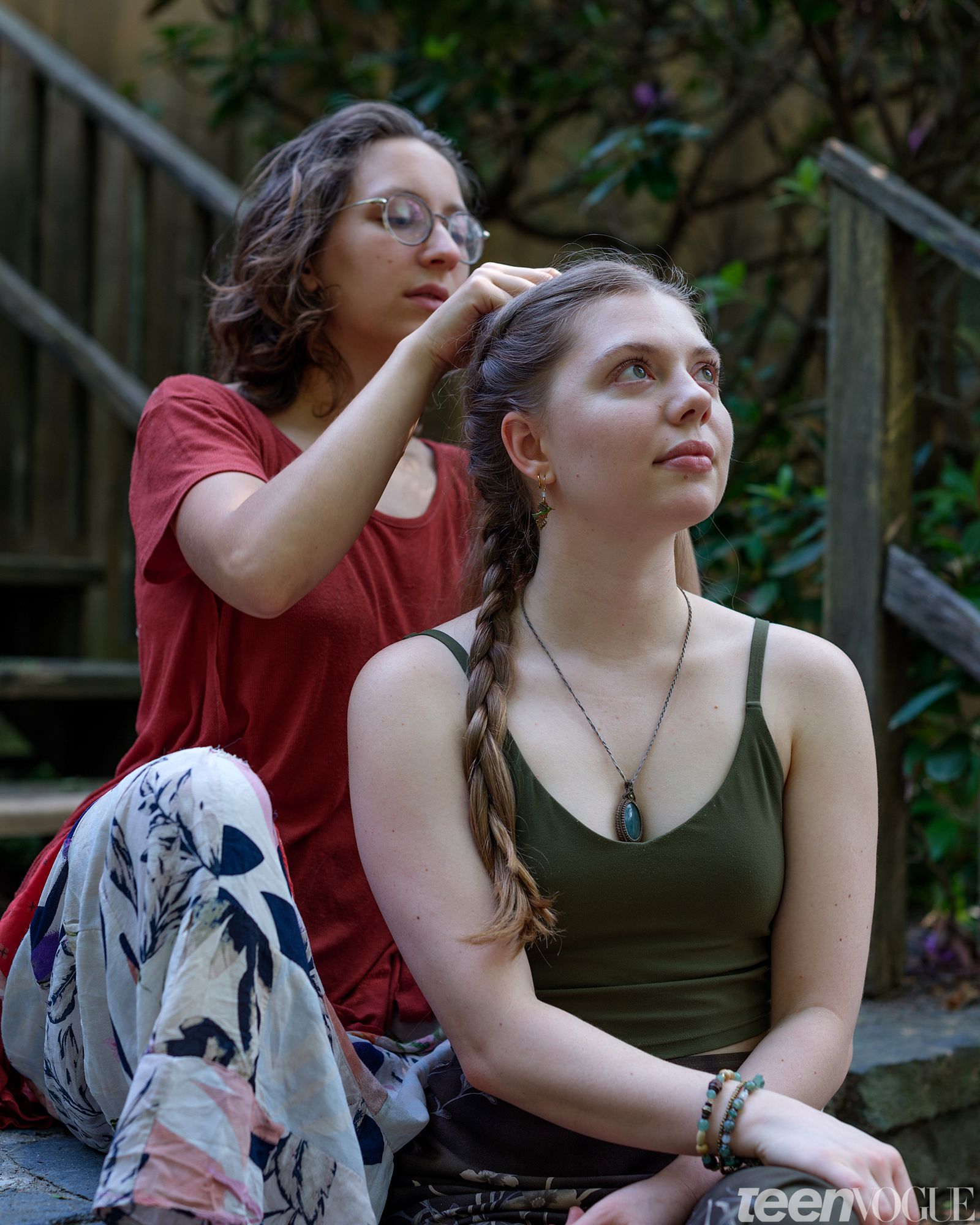 Jo braids Madison's hair on the steps in Shutesbury Massachusetts. Both looking away from viewer.
