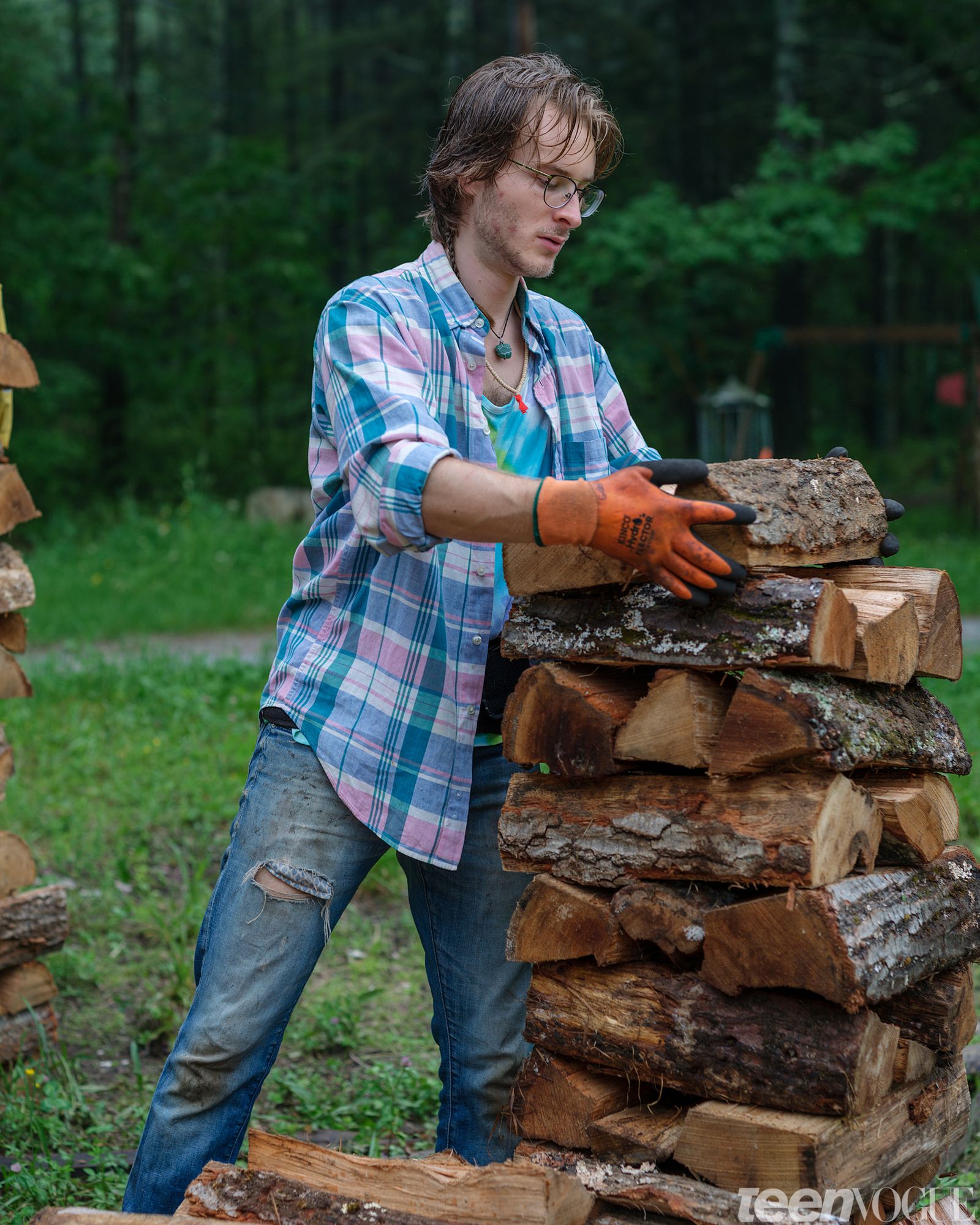 Gabriel Futterman of the Sirius Community photographed in Shutesbury Massachusetts stacking logs outside.