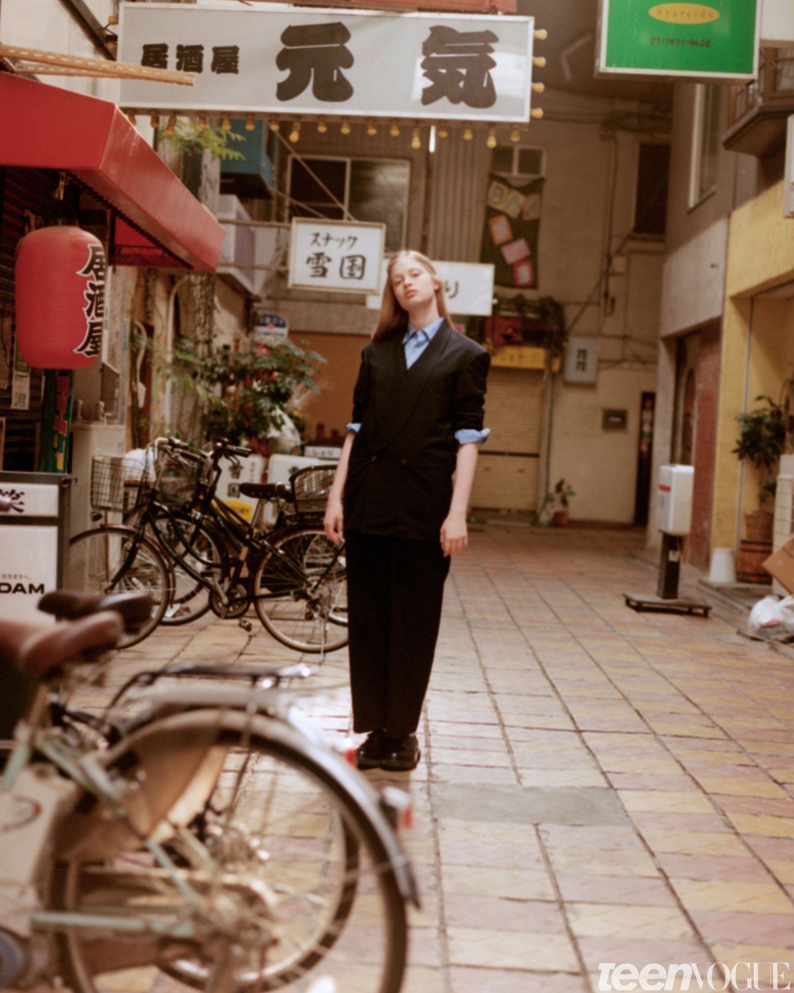 Vivian photographed outside in Tokyo wearing a matching jacket and pants.